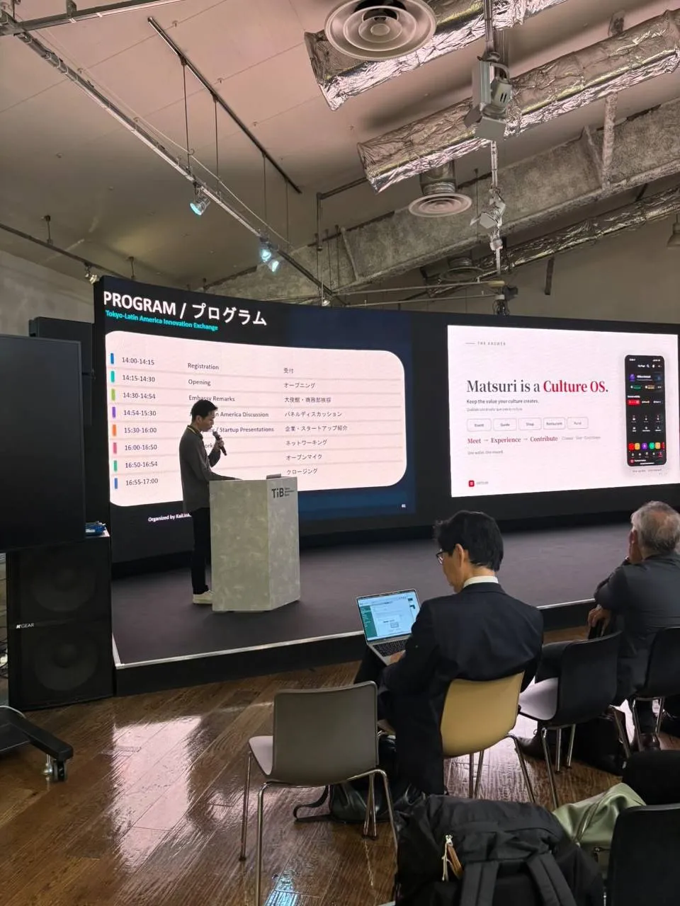 スクリーンに「Matsuri is a Culture OS.」と映し、会場で話す高橋