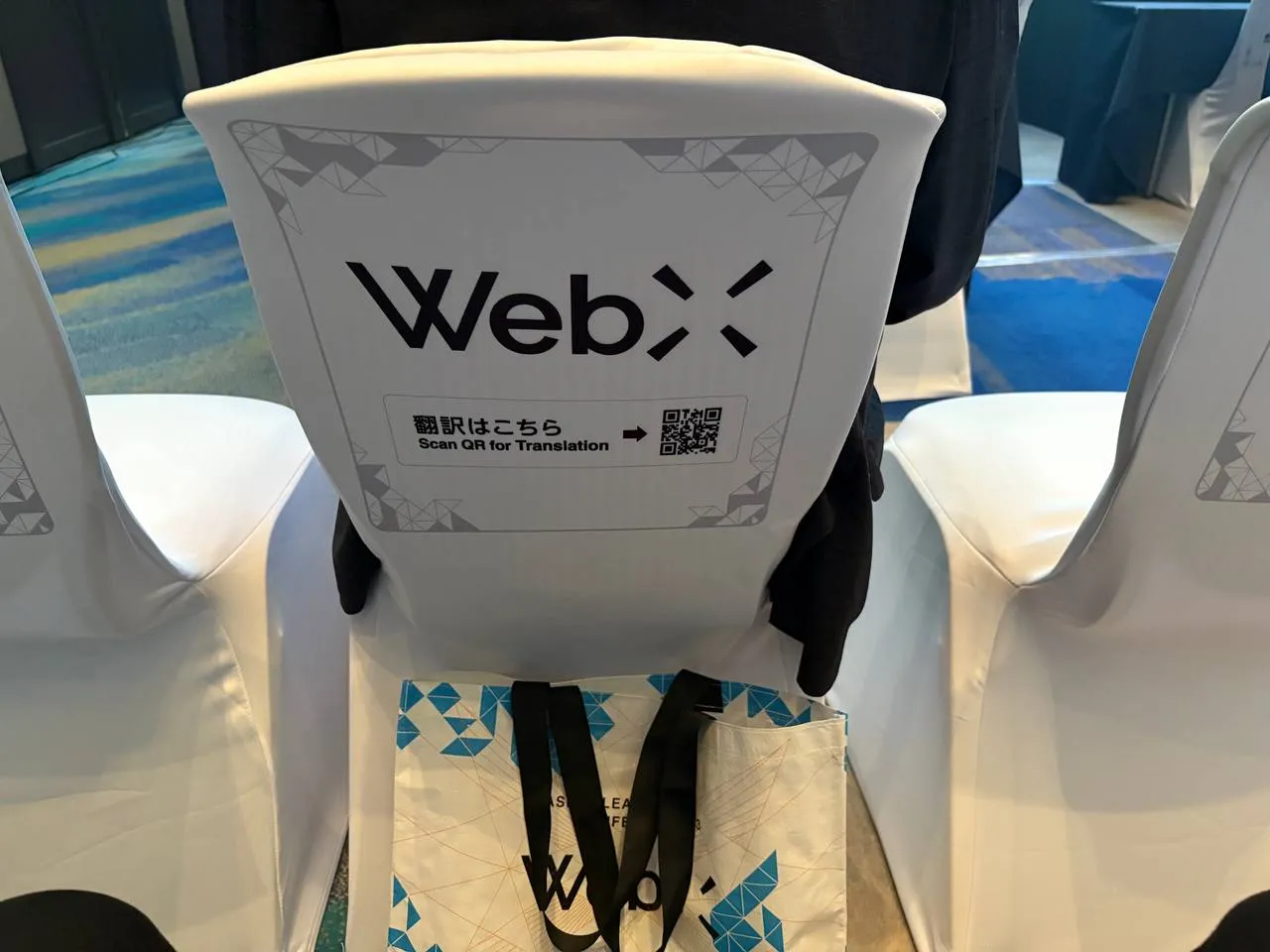 WebX 2026 の会場。ロゴ入りのカバーをかけた客席